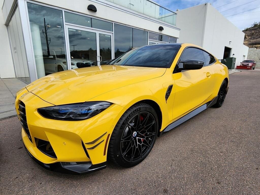 Yellow BMW M4 with ceramic tint parked outside the tint shop